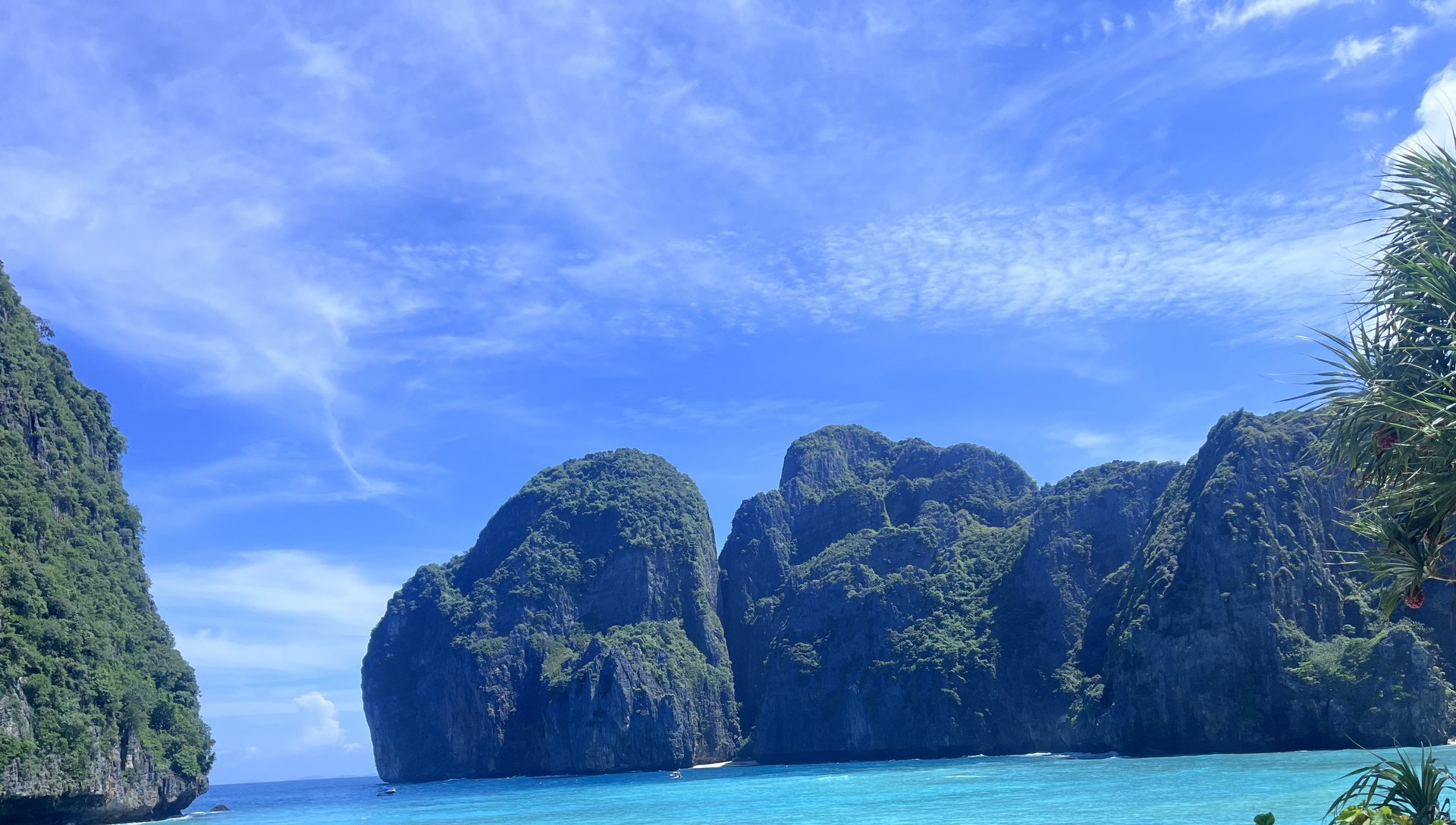 Turquoise water in a quiet coastal cove framed by green limestone cliffs